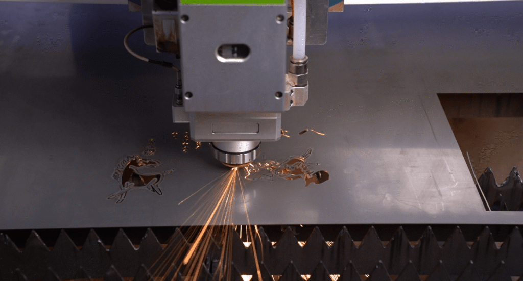 Laser cutting head cutting intricate metal patterns