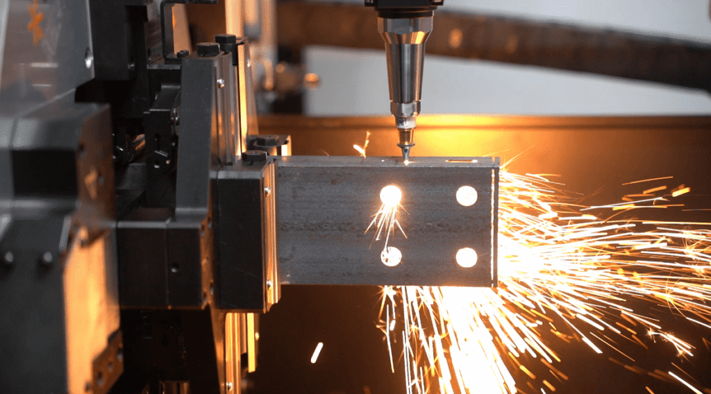 Laser cutting machine drilling holes on steel tube, high-efficiency metal pipe cutting with sparks