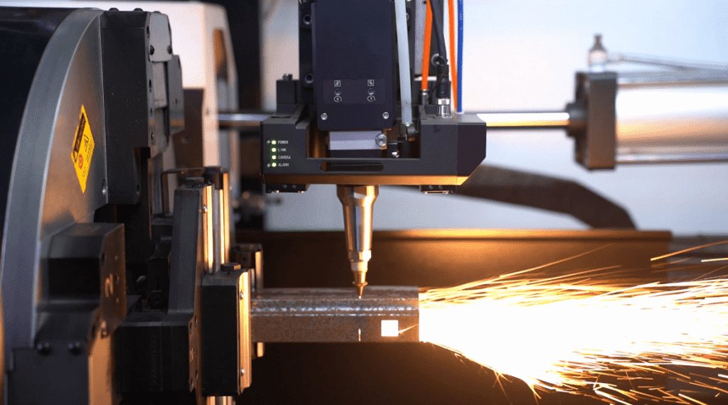 Close-up of a laser chuck laser nozzle cutting square steel tube with intense sparks.