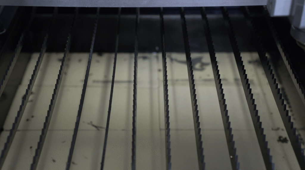 Close-up of slatted metal laser cutting table.