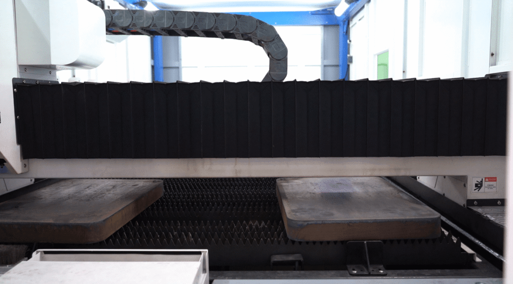 Heavy metal plates on a fiber laser cutting bed.