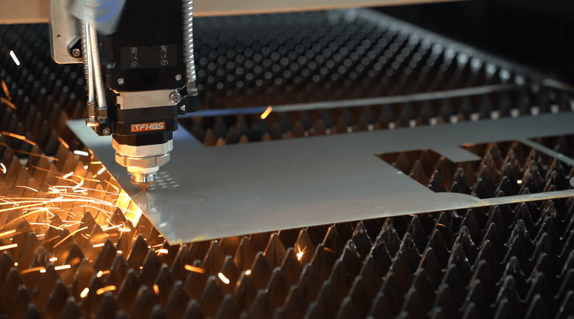 Industrial fiber laser cutter working on a large metal plate.