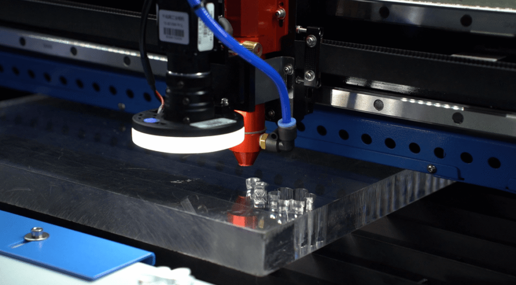 Focused laser beam piercing through thick industrial metal.