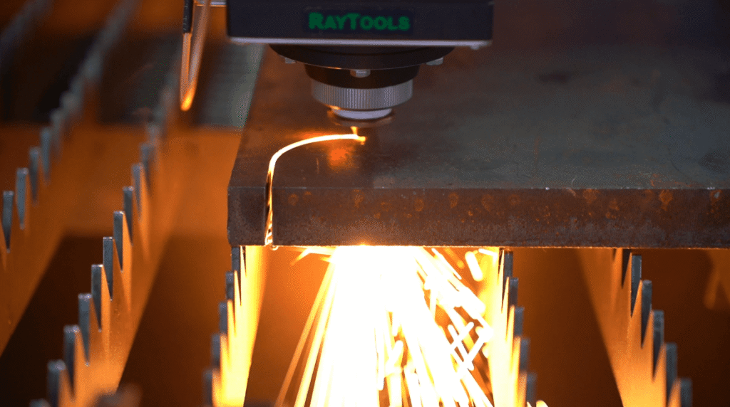 Laserkopf schneidet Metallplatte mit Funkenbildung (Nahaufnahme)