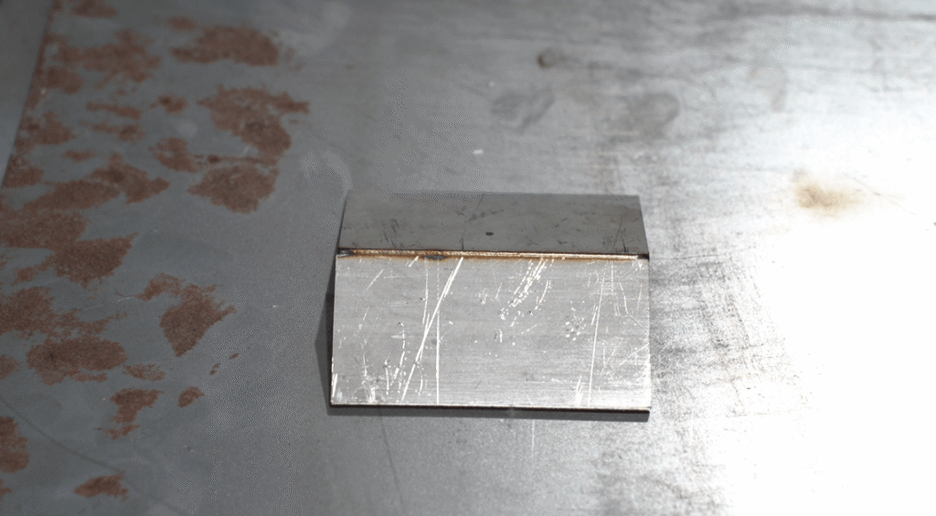 Fertige Laserschweißnaht an zwei zusammengefügten Metallplatten auf der Werkbank.