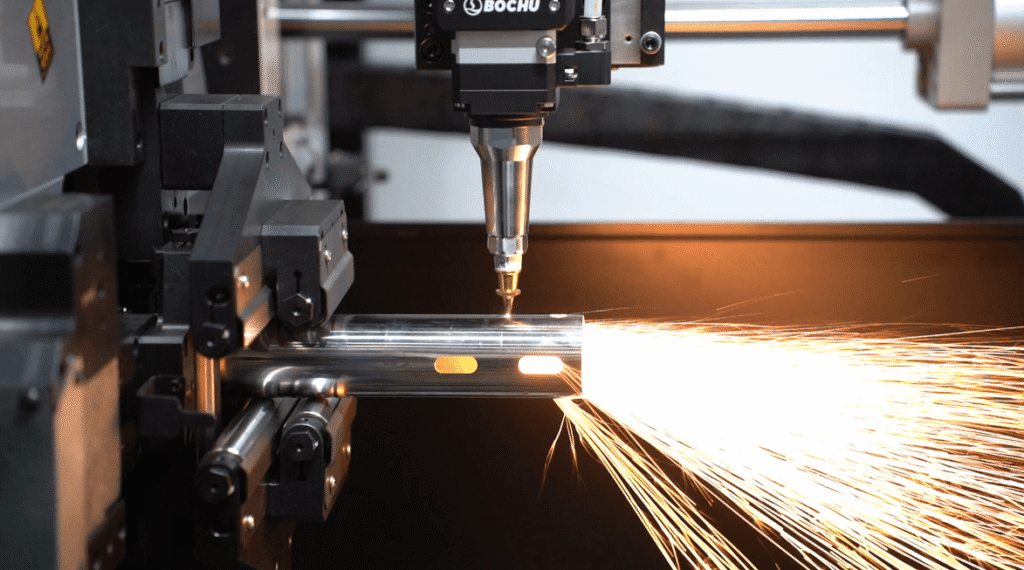 Tête laser Bochu découpant des fentes sur un tube en acier avec des étincelles.