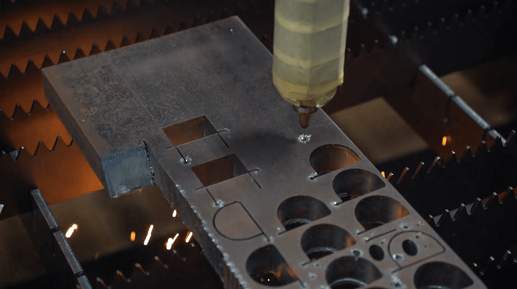 CNC laser machine piercing multiple round holes and complex shapes in metal.