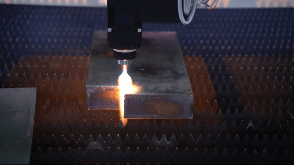 Laser flame composite cutting machine piercing a thick carbon steel block.