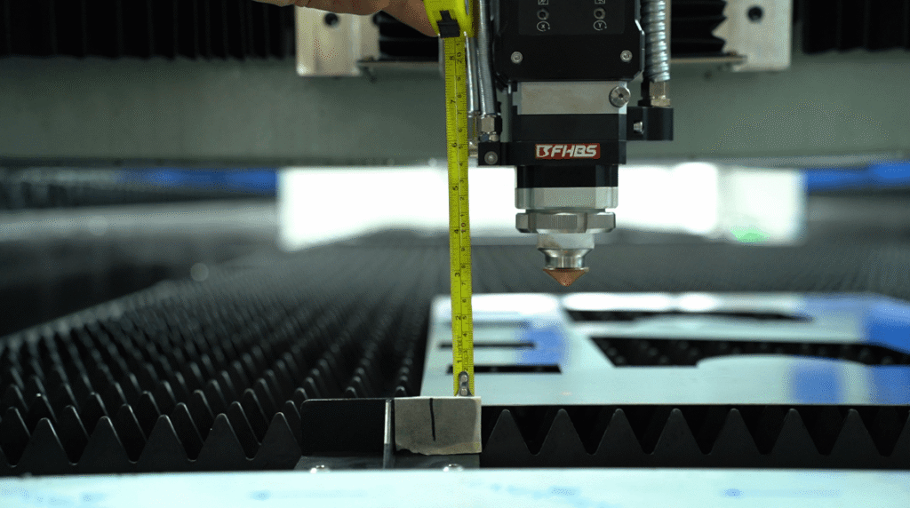 Measuring the focal distance under the laser cutting head with a tape.