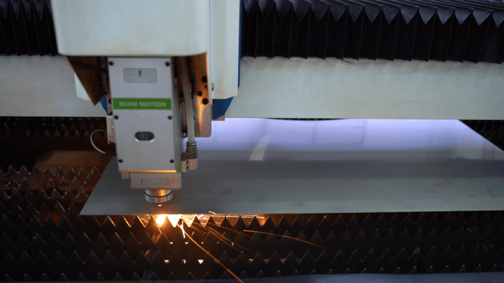 Close-up of a laser cutting nozzle processing sheet metal.
