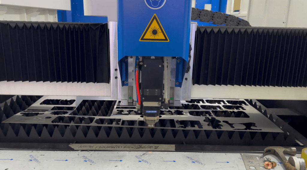 Industrial laser cutting machine cutting intricate metal parts.