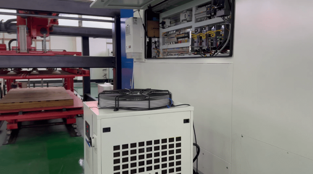 Industrial chiller unit next to a laser machine inside a workshop.