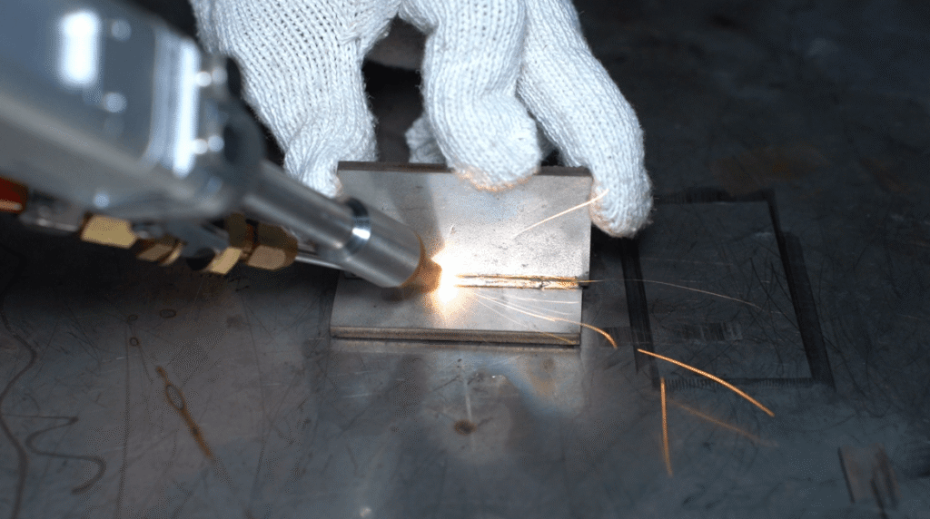 Close-up of Baison laser welding head and wire feed nozzle.