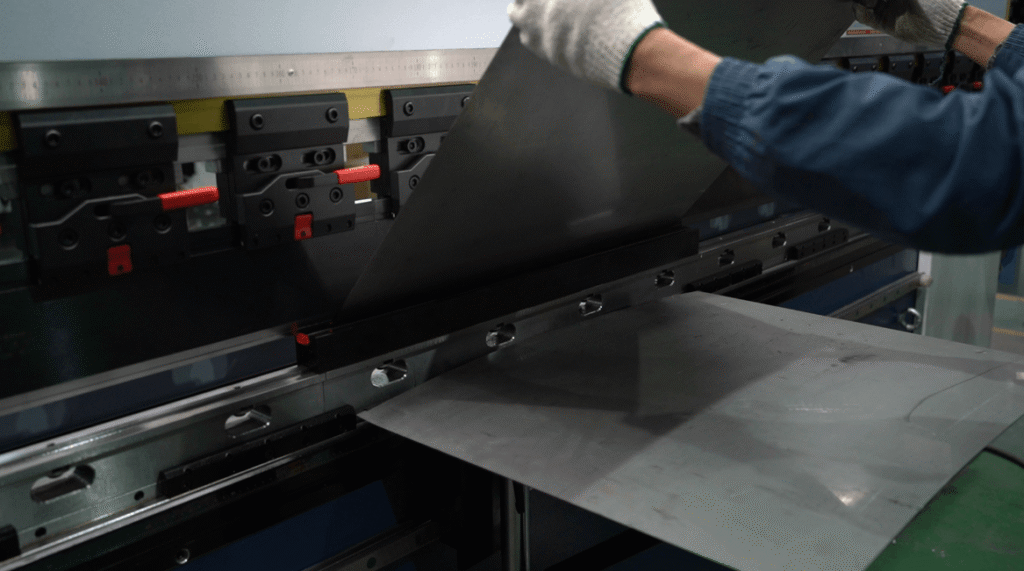 Worker operating Baison CNC press brake for sheet metal bending.