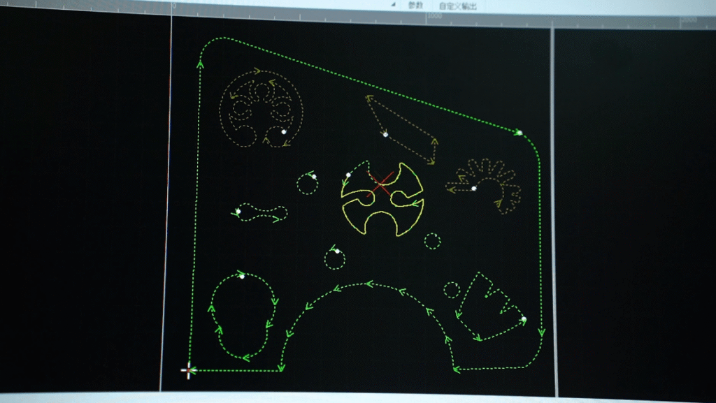 Monitor showing green laser cutting path software.