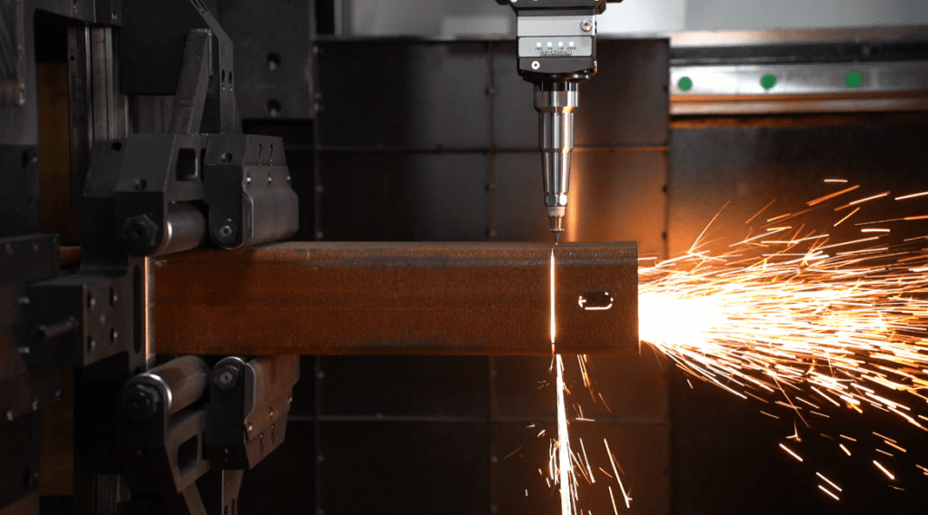 Laser head cutting square steel tube with sparks flying sideways.