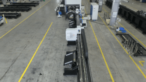 Long tube laser cutting machine with loading system in workshop.