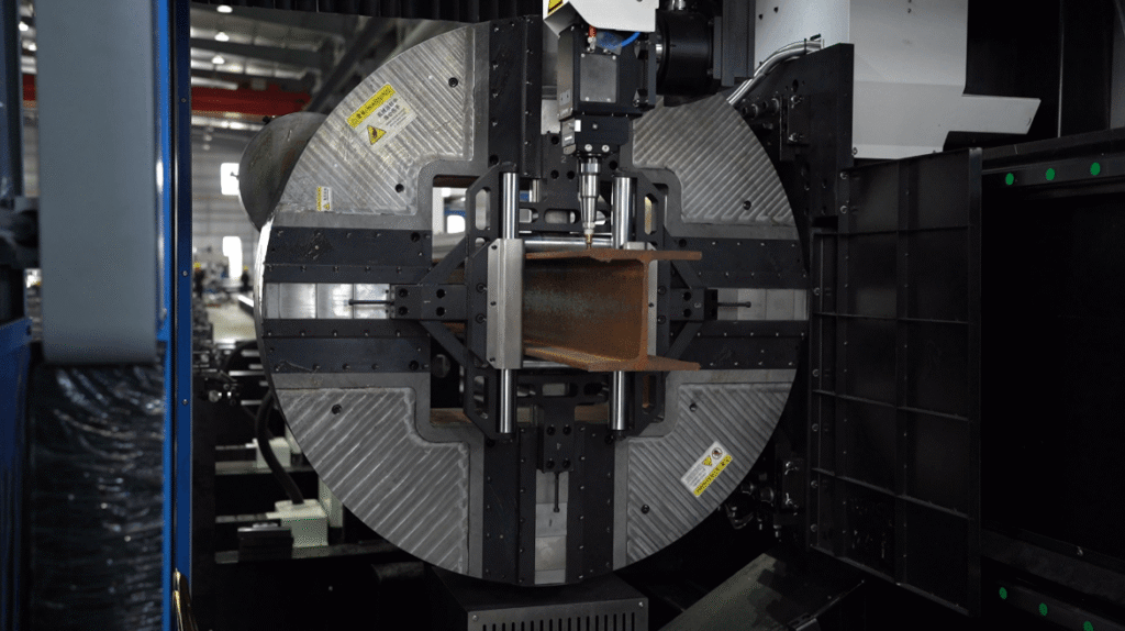 Chuck and laser head cutting H-beam close-up.