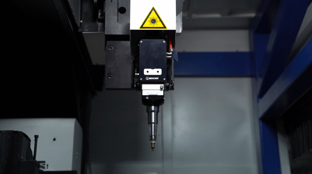 Laser head cutting steel tube from outside with sparks.