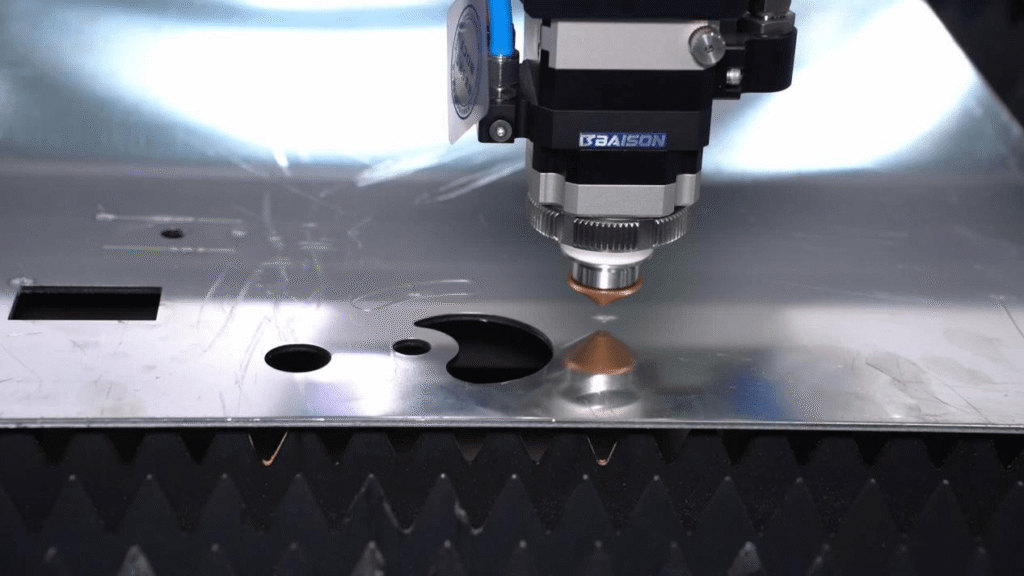 Primer plano de una cortadora láser BAISON cortando una lámina de metal.