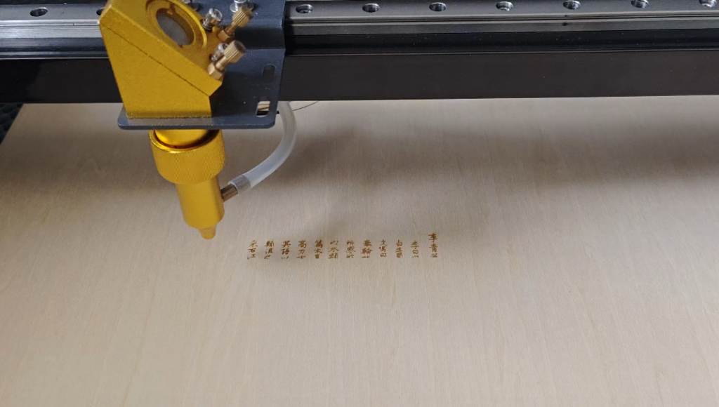 Baison laser equipment performing fine engraving of Chinese characters on a wooden board.