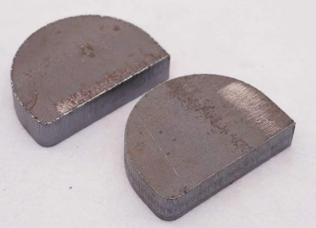 Top-down view of finished laser-cut metal samples, showing burr-free cuts.