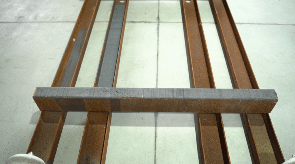 Steel beam with a partially laser-cleaned surface.