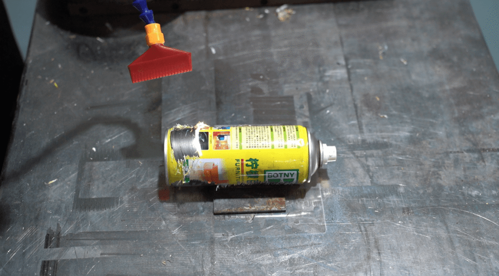 Pulsed laser removing paint and labels from a metal can.
