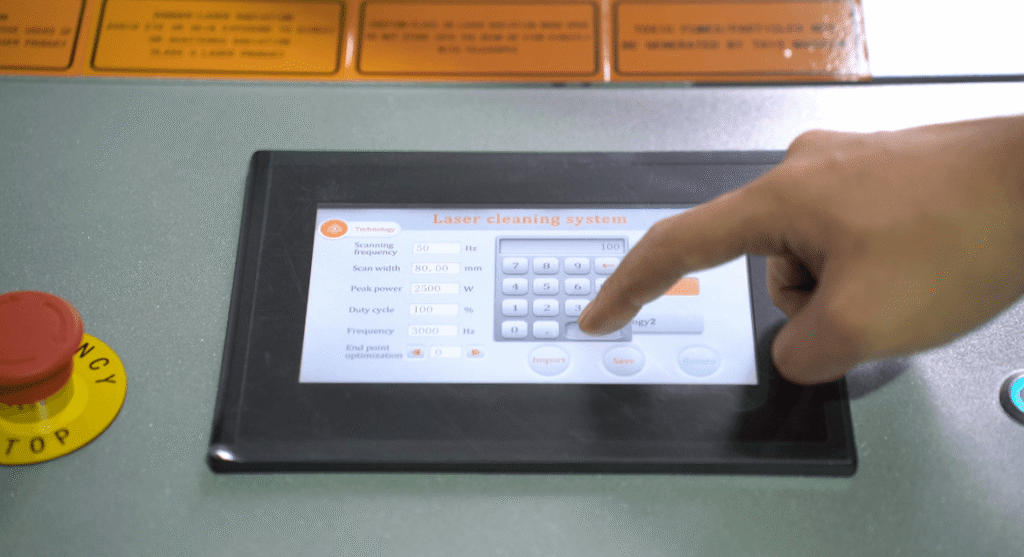 Finger touching the screen of a laser cleaning system control panel.