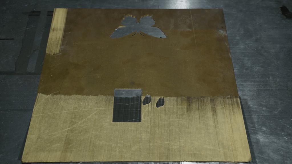 Brass plate sample with laser-cut butterfly and cleaned area