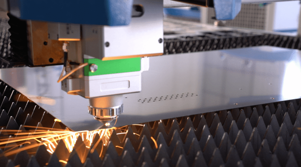 High-power laser cutting head cutting metal with sparks.