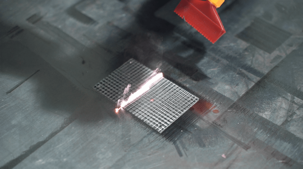 Handheld laser cleaning contaminants from fine metal mesh.