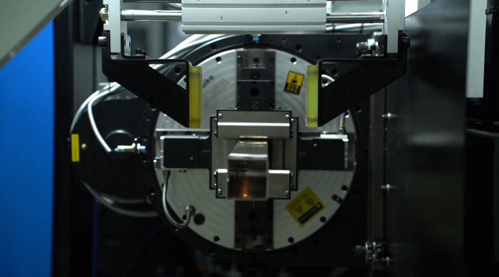 Close-up of laser cutter chuck holding square tube