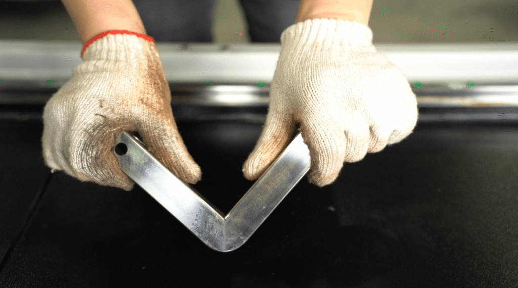Worker holding cut metal part