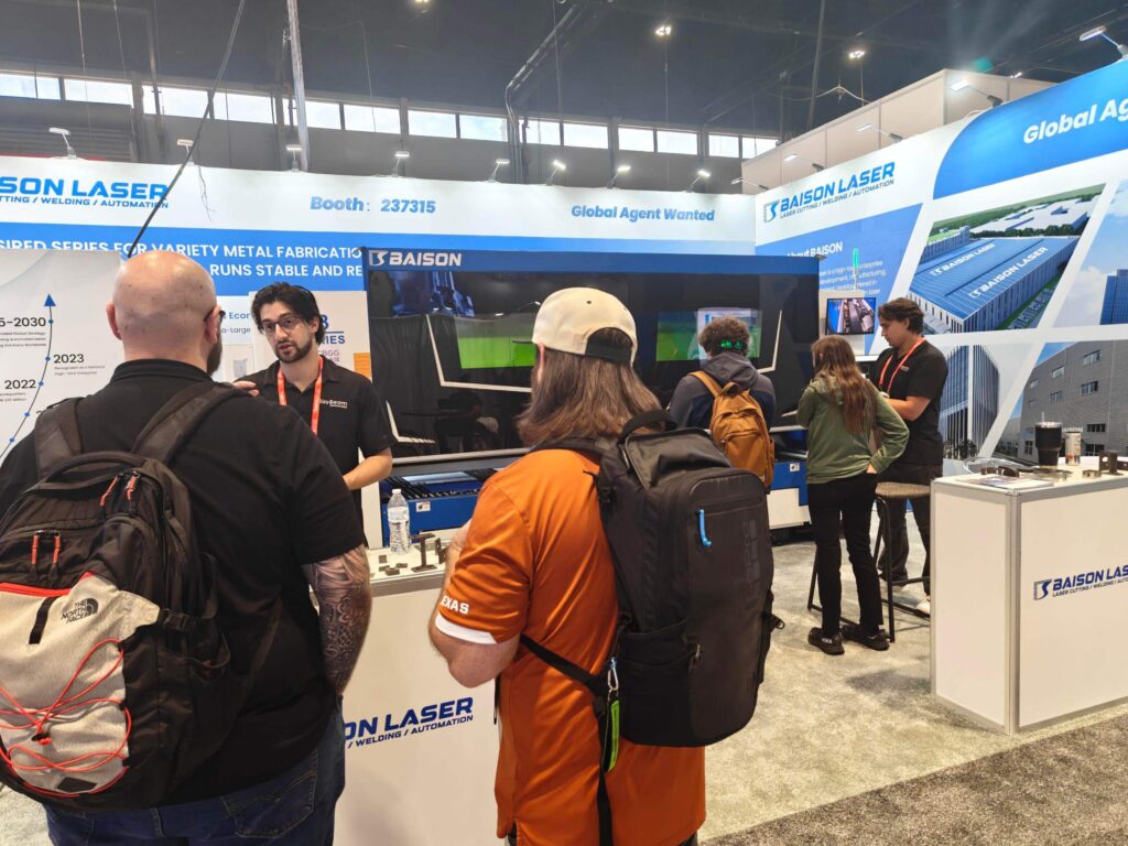 Engineers discussing M3 laser cutter at IMTS.