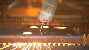 Inclined laser cutting head performing bevel angle cut on thick steel plate.