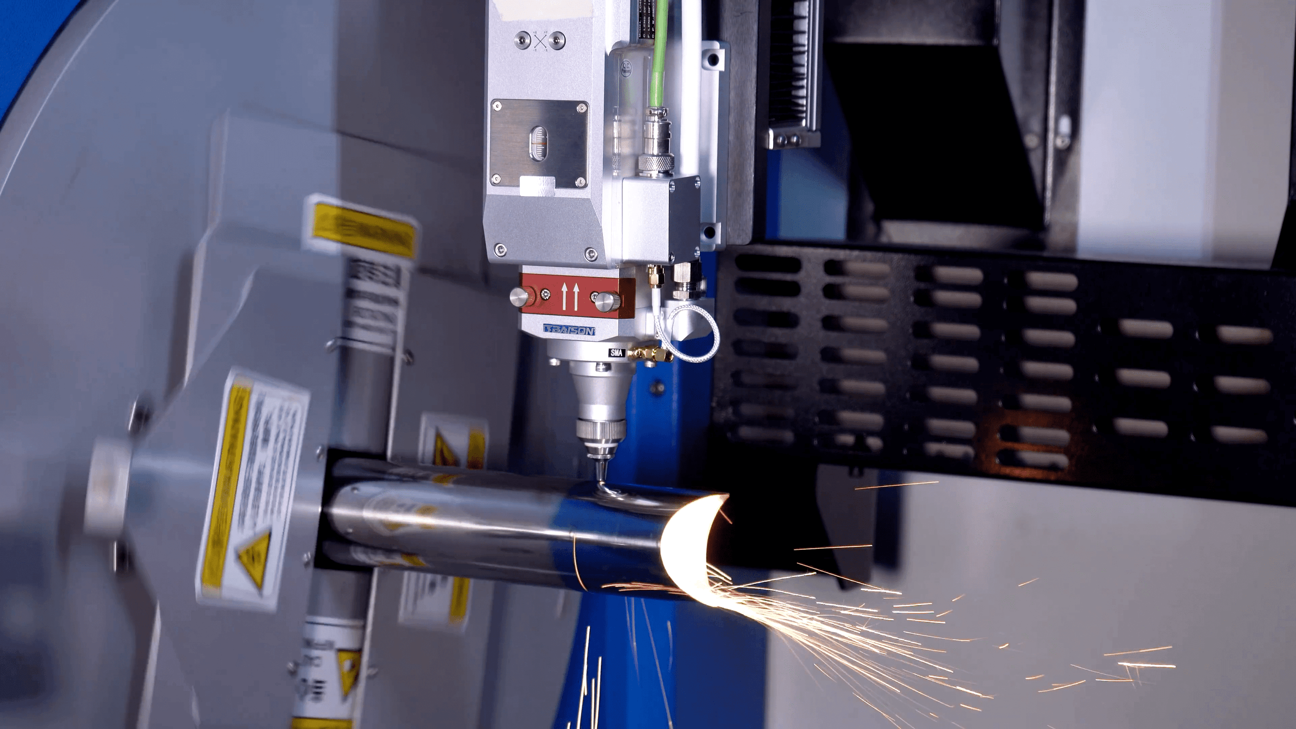Laser cutting head precision processing a rotating steel tube on Baison G24.